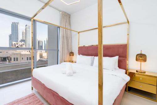 een slaapkamer met een bed en een groot raam bij Burj Khalifa View 2BR Spacious Bellevue Tower in Dubai