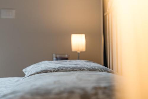 um quarto com uma cama com um candeeiro em Casa Elsa - Lago d'Orta em Orta San Giulio