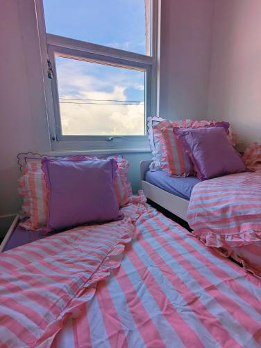 a room with two beds and a window at pet + kid friendly free parking v pink house! in Brighton & Hove