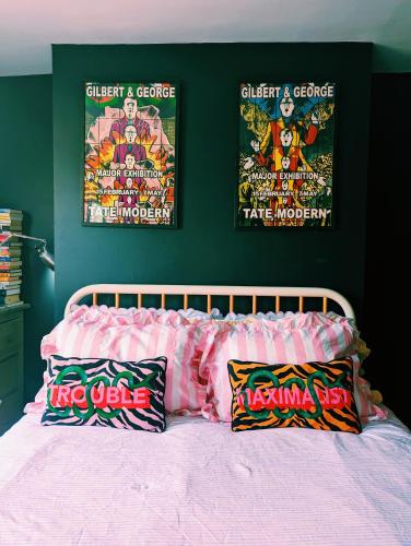 a bedroom with a bed with two posters on the wall at pet + kid friendly free parking v pink house! in Brighton & Hove