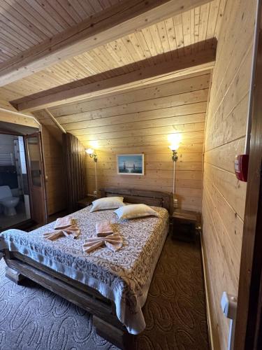 1 dormitorio con 1 cama en una habitación de madera en Palaga Bukovel, en Bukovel