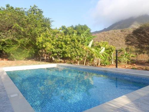 a swimming pool with a mountain in the background at Posada Casa Las Trinitarias in Paraguchi