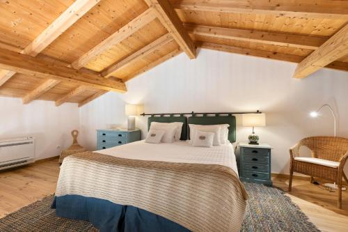 sypialnia z dużym łóżkiem i drewnianym sufitem w obiekcie Quinta da Donalda w mieście Portimão