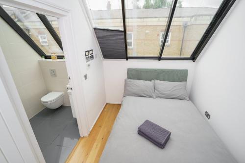 a small room with a bed and a toilet at En-suite Room in Zone 1 London in London