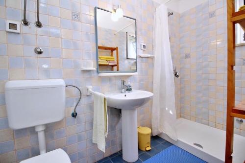 a bathroom with a sink and a toilet and a mirror at Apartment Bujas in Šilo