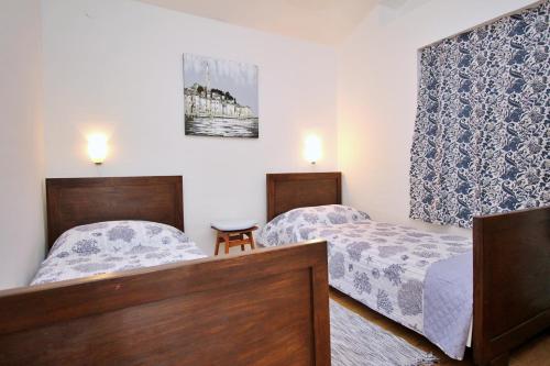 two beds in a small room with two lamps at Apartment Bujas in Šilo