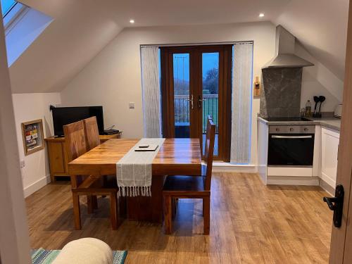 a kitchen with a wooden table with chairs and a kitchen at Lakeside Loft in Hereford