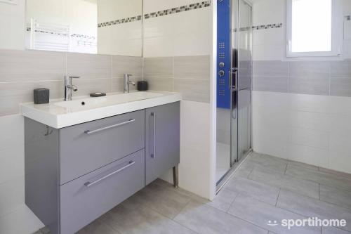 een witte badkamer met een wastafel en een douche bij Ferme en pleine campagne in Castelsagrat