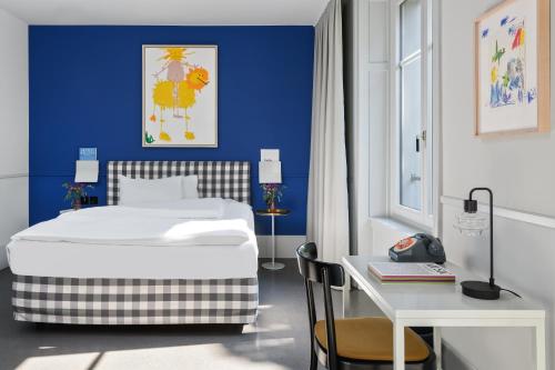 1 dormitorio con cama blanca y pared azul en Boutique & Art Hotel Helvetia, en Zúrich