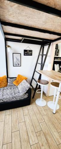 Cette chambre comprend un lit, une table et une échelle. dans l'établissement STUDIO- NICE MONT BORON, PISCINE SUR LA RESIDENCE, à Nice