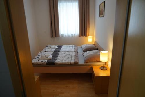 ein kleines Schlafzimmer mit einem Bett und einem Fenster in der Unterkunft APARTMA My HILL 5 in Maribor