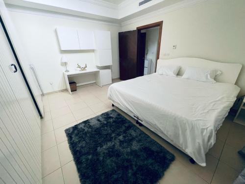 a bedroom with a large white bed and a rug at lovely one bedroom self entry in Jeddah