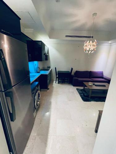 a kitchen and a living room with a couch at lovely one bedroom self entry in Jeddah