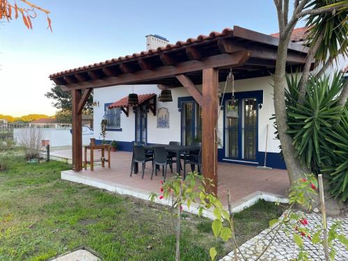 a wooden pergola with a table and chairs on a deck at Monte Velho - Country House in Canha