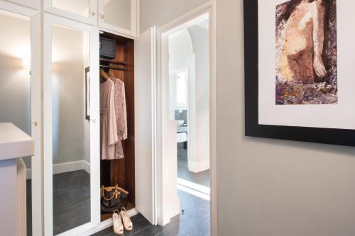 a dressing room with a mirror and a closet at Tornabuoni Suites Collection Residenza D'Epoca in Florence