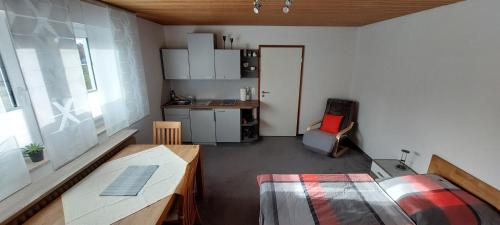 a small room with a table and a kitchen at Ferienwohnung Stempfle in Oettingen in Bayern