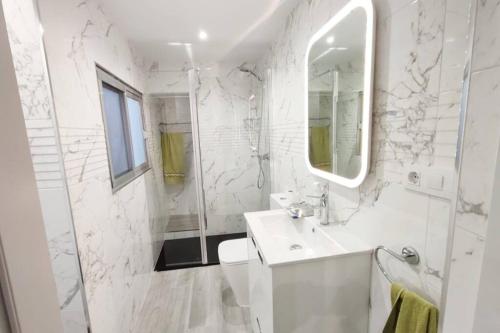 Baño blanco con lavabo y espejo en Acogedora casa en Llíria, en Liria