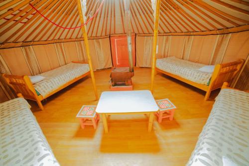 Zimmer mit 2 Betten und einem Tisch in einer Jurte in der Unterkunft Stepperiders in Ulaanbaatar