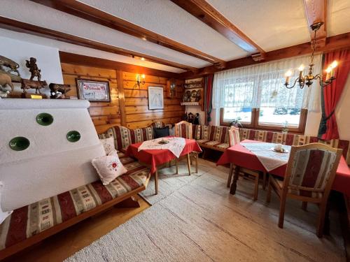 ein Esszimmer mit Tischen und Stühlen in einem Raum mit Holzwänden in der Unterkunft Apartment Wiesenhof - LFD201 by Interhome in Längenfeld