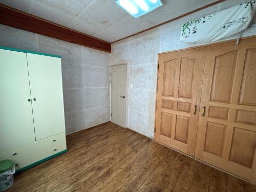 pusty pokój z drewnianymi drzwiami i drewnianą podłogą w obiekcie Sunset Hanok Stay w mieście Suncheon