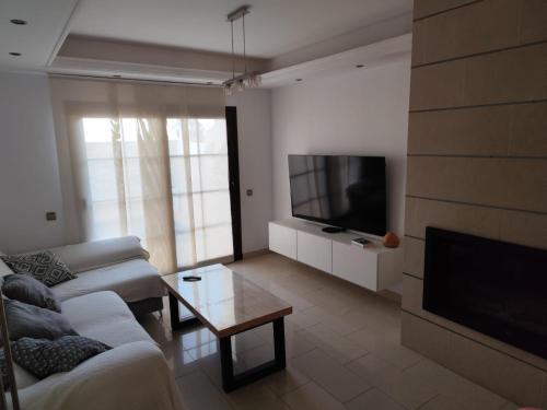 uma sala de estar com um sofá e uma televisão de ecrã plano em CASA MAR Y MONTE em Ojén