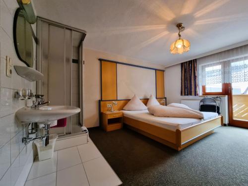 ein Hotelzimmer mit einem Bett und einem Waschbecken in der Unterkunft Apartment Monika - KPL562 by Interhome in Kappl