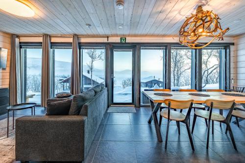 une salle à manger avec une table, des chaises et un lustre dans l'établissement Korppi Mökki, à Kilpisjärvi