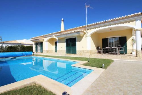 a villa with a swimming pool in front of a house at Bonita Moradia c/ Piscina em SAGRES in Sagres