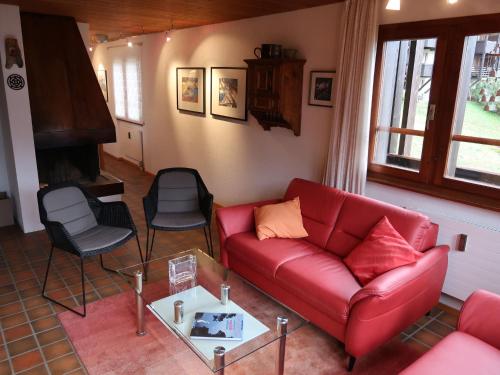 フィエッシュにあるApartment Aragon T100 by Interhomeのリビングルーム(赤いソファ、椅子付)