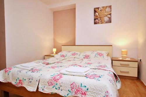 a bedroom with a bed with two towels on it at Apartments Car Lj. in Šilo