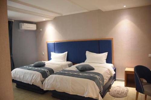 two beds sitting next to each other in a room at Hotel Royal Palace in Douala