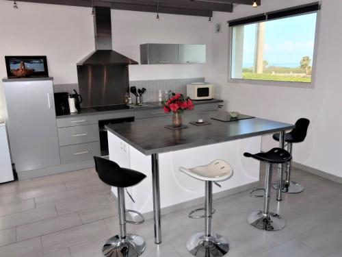 Una cocina con encimera y taburetes. en Holiday Home Brise Marine by Interhome, en Cléder
