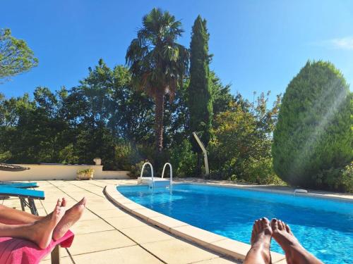 a person laying on a chair next to a swimming pool at Holiday Home Le Coustal - BSB300 by Interhome in Blanquefort-sur-Briolance