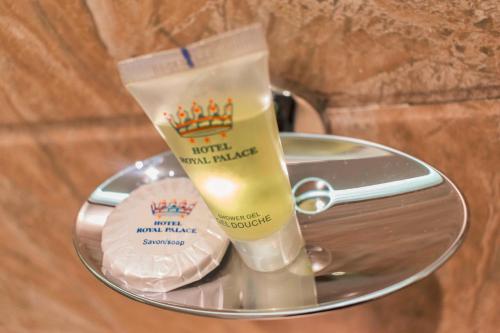 a glass table with two bottles of moisturizing moisturizing candles at Hotel Royal Palace in Douala