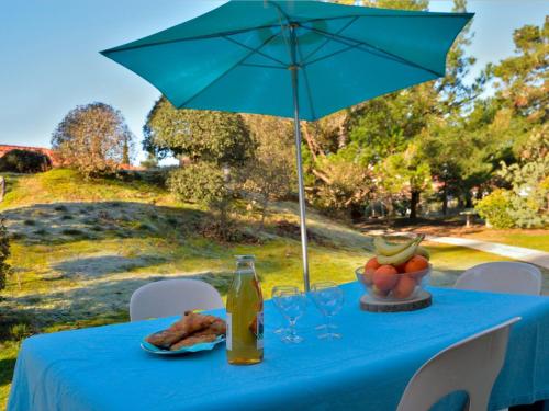 a blue table with an umbrella and a plate of food at Holiday Home Hameau Océan - SHR101 by Interhome in La Parée Preneau
