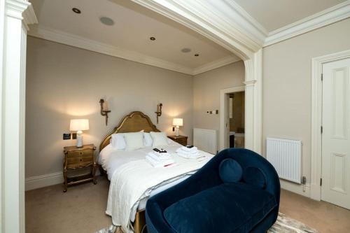 1 dormitorio con 1 cama y 1 silla azul en 6* Royal Garden Suite Private Island Lake District, en Caton