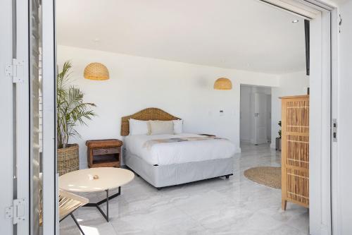 1 dormitorio con 1 cama y 1 mesa en Endless Summer Beach House, en Bloubergstrand