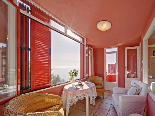 a living room with a table and chairs and windows at Apartment Muralla Roja-1 by Interhome in Calpe