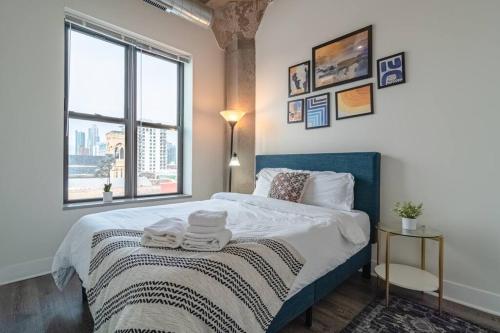 1 dormitorio con 1 cama grande y toallas. en McCormick 2Br/2Ba family unit for up to 6 guests with Skyline view, Optional Parking & Gym access, en Chicago