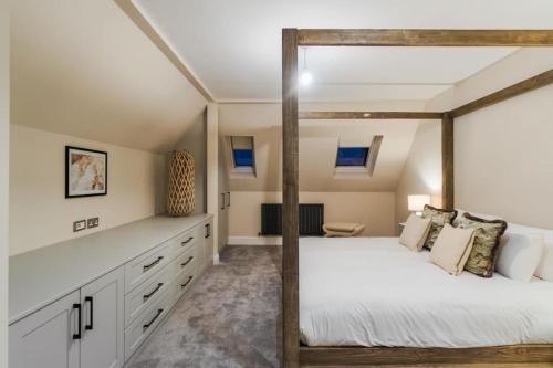 - une chambre avec un lit à baldaquin et des armoires blanches dans l'établissement 3BR Retreat, Allocated Parking, Private Garden, à Windsor