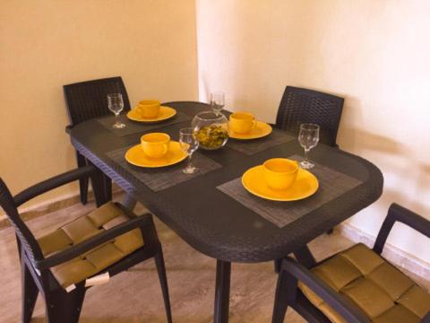 a black table with yellow plates and glasses on it at NOUVEAU, Residence Cap Spartel avec une vue sur mer in Tangier