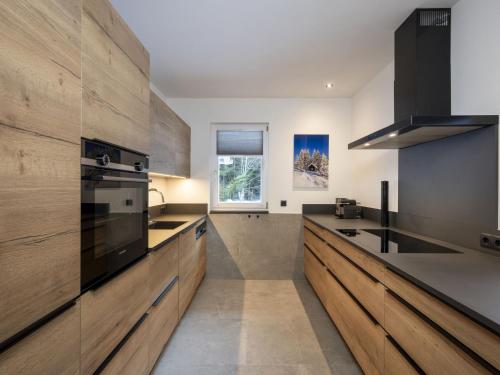 a kitchen with wooden cabinets and a sink at Holiday Home Steindlwald by Interhome in Untertauern