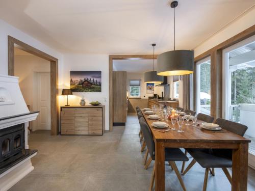 a dining room with a long table and a fireplace at Holiday Home Steindlwald by Interhome in Untertauern