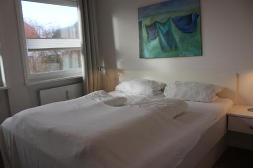 uma cama branca num quarto com uma janela em Mühlenstraße em Wyk auf Föhr