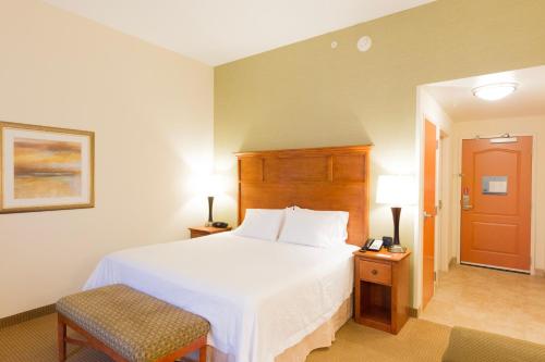 a bedroom with a large white bed and a chair at Hampton Inn & Suites Radcliff/Fort Knox in Radcliff