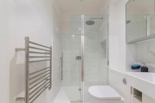 e bagno con doccia, servizi igienici e lavandino. di Stunning 1-bed Flat in London 20 mins from Central London a Londra