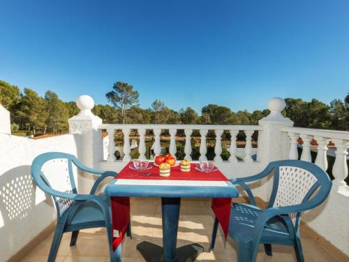 a table on a balcony with two chairs and a table with flowers on it at Holiday Home Blanca by Interhome in Miami Platja