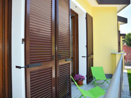 サヴォーナにあるApartment Acero - SBO104 by Interhomeの木製のドアとバルコニーの椅子が備わる家