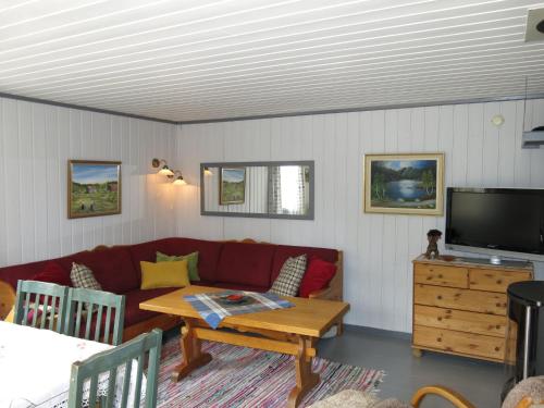 salon z kanapą i stołem w obiekcie Chalet Sandrabu - SOW056 by Interhome w mieście Øyuvstad