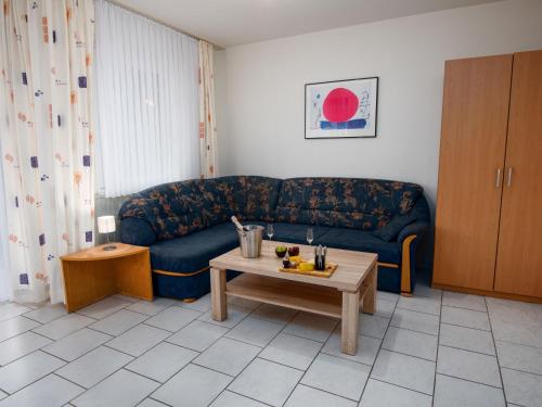 ノルトダイヒにあるApartment Deichblick by Interhomeのリビングルーム(青いソファ、コーヒーテーブル付)